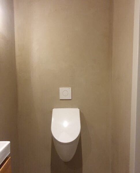 Toilet Strak modern beton stuc in een woonkamer door Room Designers